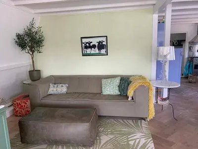 a living room with a brown couch and a table at ´t Kappershuis in Groet