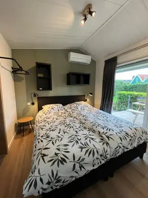 a bedroom with a bed with a black and white comforter at Amsterdam The Stables in Oostzaan