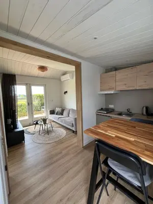 a kitchen and living room with a couch and a table at Amsterdam The Stables in Oostzaan