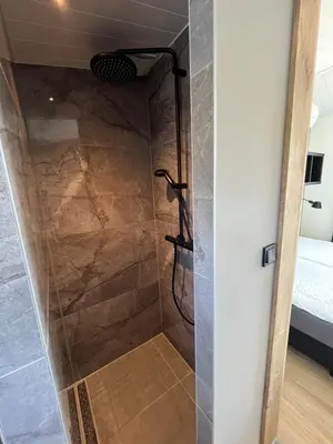 a shower with a glass door in a bathroom at Amsterdam The Stables in Oostzaan