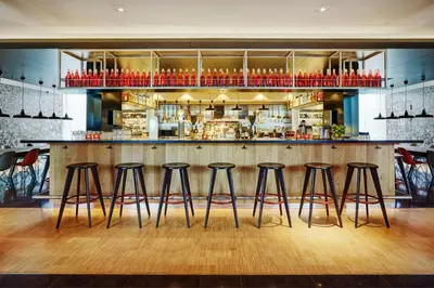 a bar with four bar stools in a restaurant at citizenM Schiphol Airport in Schiphol