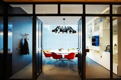 a dining room with a table and red chairs at citizenM Schiphol Airport in Schiphol