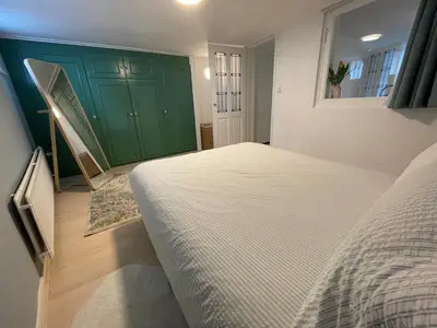 a bedroom with a bed and a green cabinet at Strandzicht Zandvoort Boulevard Apartments in Zandvoort