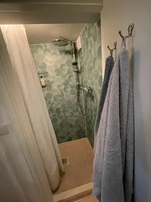 a bathroom with a shower with two towels at Strandzicht Zandvoort Boulevard Apartments in Zandvoort
