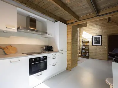 a kitchen with white cabinets and a wooden ceiling at Amaryllis in Soesterberg