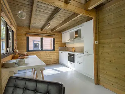 a kitchen with a white counter and a table in a room at Amaryllis in Soesterberg