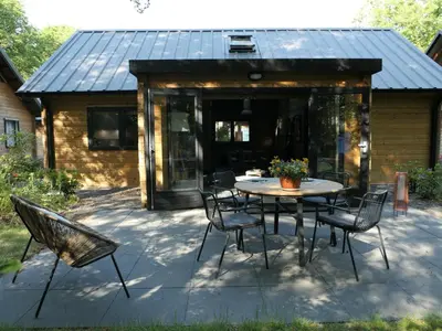 a patio with a table and chairs in front of a house at Amaryllis in Soesterberg