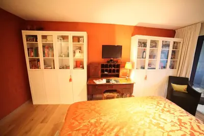 a bedroom with a bed and a desk with a television at B&B de singel in Utrecht