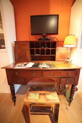 a wooden desk with a television on top of it at B&B de singel in Utrecht
