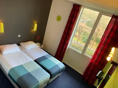 a bedroom with a bed and a large window at Hotel Oorsprongpark City Centre Utrecht in Utrecht