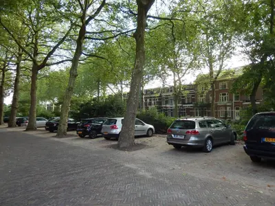 a group of cars parked in a parking lot with trees at Hotel Oorsprongpark City Centre Utrecht in Utrecht