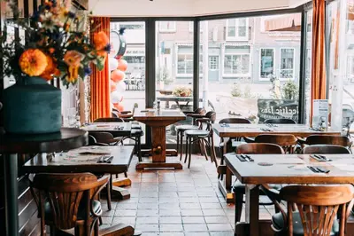 a restaurant with tables and chairs and a window at Hotel Café Restaurant Abina in Amstelveen