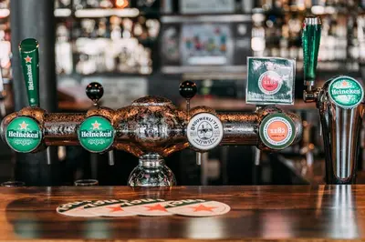 a bar with many different types of beer labels at Hotel Café Restaurant Abina in Amstelveen
