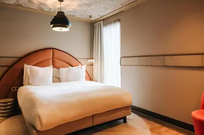 a bedroom with a large bed and a window at The Diamond Amsterdam in Amsterdam