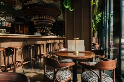 a bar with wooden tables and chairs and a counter at The Diamond Amsterdam in Amsterdam