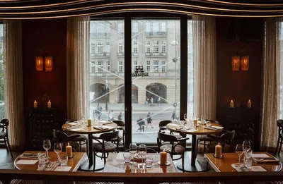 a restaurant with tables and chairs and a large window at The Diamond Amsterdam in Amsterdam