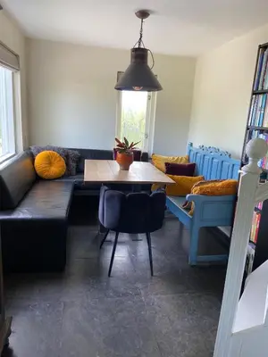 a living room with a black couch and a table at House on estate near Amsterdam and Keukenhof in Lisserbroek