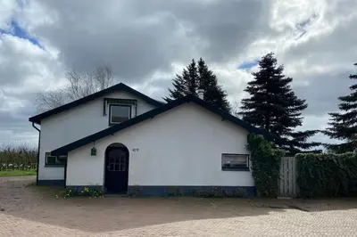 a white building with a black roof at House on estate near Amsterdam and Keukenhof in Lisserbroek