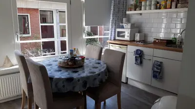 a kitchen with a table and chairs with a table and a kitchen at Bed & Breakfast WestViolet in Amsterdam