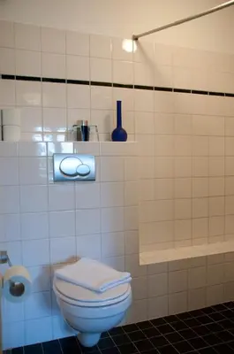 a bathroom with a toilet and a vase on a shelf at Bed & Breakfast WestViolet in Amsterdam