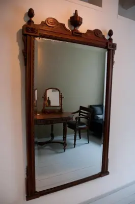 a mirror on a wall with a table and a chair at Bed & Breakfast WestViolet in Amsterdam