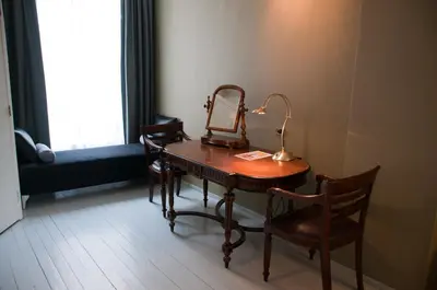 a dressing table with a mirror and a lamp on it at Bed & Breakfast WestViolet in Amsterdam