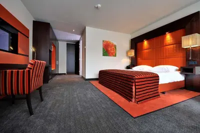 a hotel room with a bed and a chair at Van der Valk Hotel Hilversum/ De Witte Bergen in Hilversum