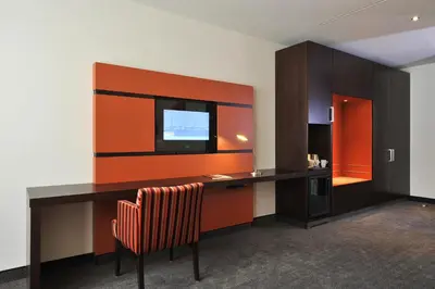 a room with a desk with a television and a chair at Van der Valk Hotel Hilversum/ De Witte Bergen in Hilversum