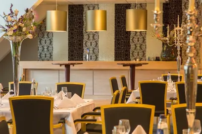a dining room with tables and yellow chairs at Van der Valk Hotel Hilversum/ De Witte Bergen in Hilversum