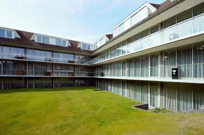 a large building with a lawn in front of it at Van der Valk Hotel Hilversum/ De Witte Bergen in Hilversum