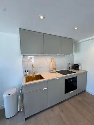 a kitchen with white cabinets and a sink at Suite Dreamz in Zandvoort
