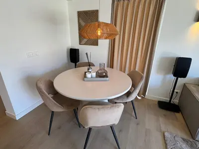 a dining room table with chairs and a lamp at Suite Dreamz in Zandvoort