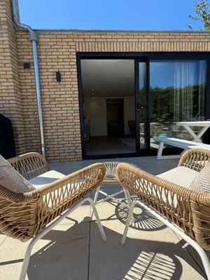 two wicker chairs sitting on top of a patio at Suite Dreamz in Zandvoort