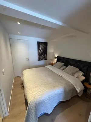 a bedroom with a large bed with a painting on the wall at Suite Dreamz in Zandvoort