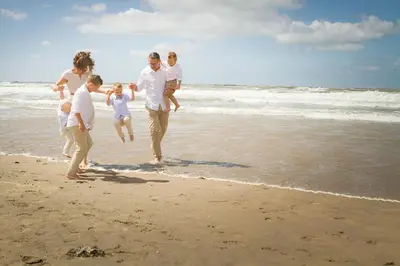 a group of people walking on the beach at SEA YOU Hotel Noordwijk in Noordwijk aan Zee