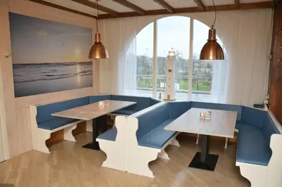 a restaurant with two tables and a window at SEA YOU Hotel Noordwijk in Noordwijk aan Zee