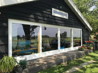 a screened porch with windows on a house at Over Lake in Monnickendam