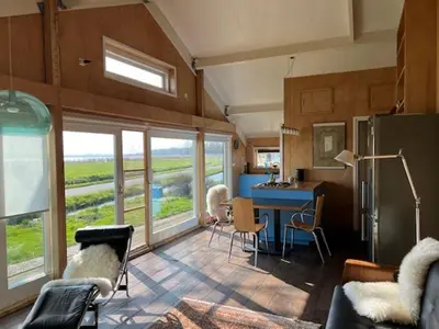 a room with a kitchen with a table and chairs at Over Lake in Monnickendam
