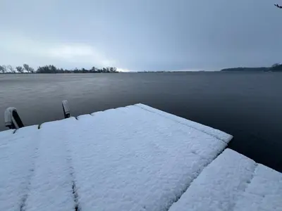 a dock covered in snow next to a body of water at Over Lake in Monnickendam