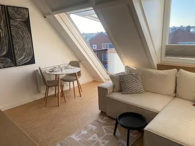 a living room with a couch and a table at LONG BEACH ROOMS 3 in Zandvoort