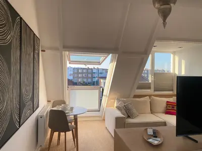 a living room with a couch and a table at LONG BEACH ROOMS 3 in Zandvoort