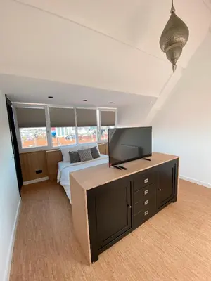 a bedroom with a bed and a flat screen tv at LONG BEACH ROOMS 3 in Zandvoort