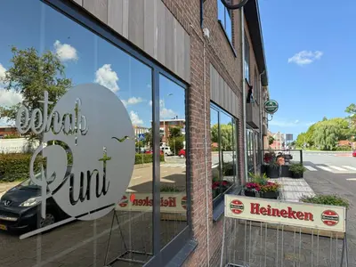 a store with a sign on the side of a building at Eetcafé Punt in Roelofarendsveen