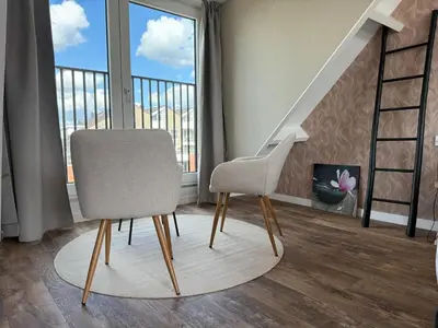 a living room with a chair and a staircase at Eetcafé Punt in Roelofarendsveen