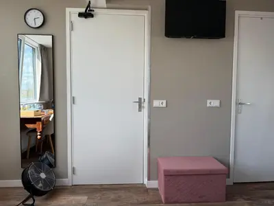a room with a door and a table and a clock at Eetcafé Punt in Roelofarendsveen