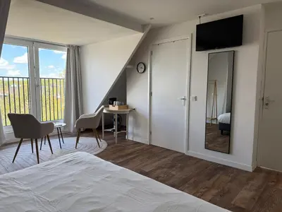 a bedroom with a bed and a table and a mirror at Eetcafé Punt in Roelofarendsveen