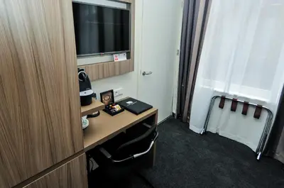 a room with a desk with a computer and a window at Hotel Fine Harmony in Amsterdam