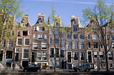 an apartment building in amsterdam with cars parked in front at Hotel Fine Harmony in Amsterdam
