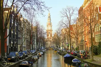 a city street with a clock tower and cars parked at Hotel Fine Harmony in Amsterdam