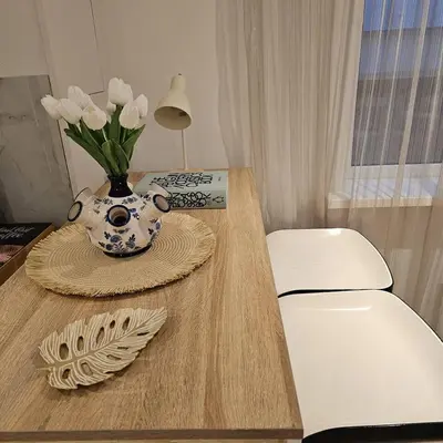 a vase of flowers on a table with a lamp at Charming Apartment in Lisse - 30 sqm with Terrace in Lisse